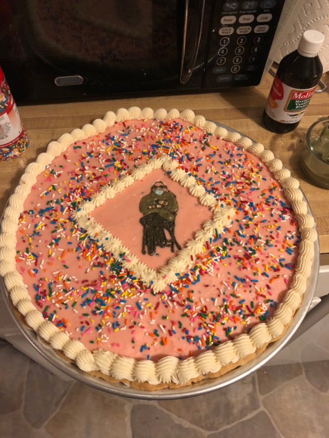 PHOTO Bernie Sanders With His Mittens On Put On A Giant Chocolate Chip Cookie