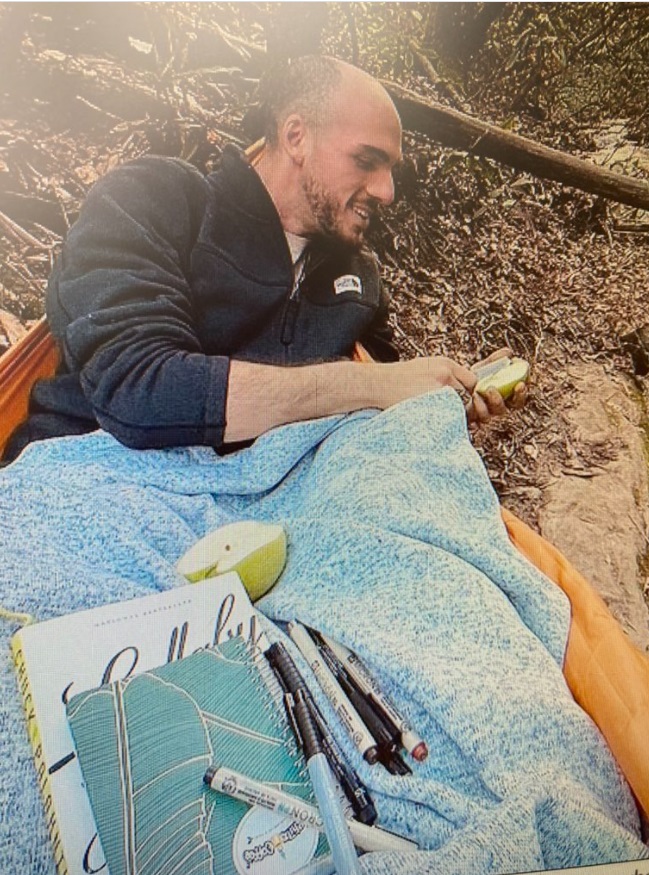 PHOTO Brian Laundrie Smiling While Eating A Pear And Reading Books At A National Park