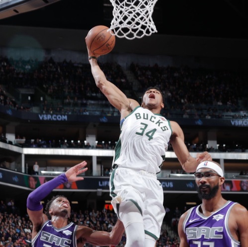 Corey Brewer Looks Straight In Front Of Himself As Giannis Dunks Behind Him Still Shot