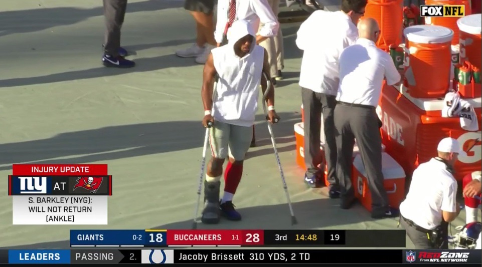 PHOTO Saquon Barkley Walking On Sideline With Crutches And A Walking Boo