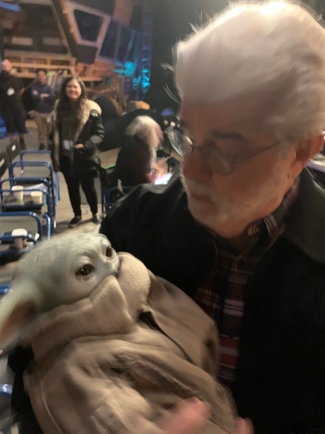 PHOTO George Lucas Holding Baby Yoda Like He's Real