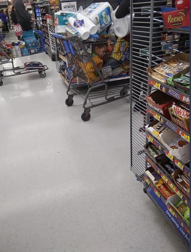 PHOTO Young Kid Trapped In Shopping Cart Under A Full Cart Of Groceries As His Mother Stocks Up During Corona Virus Pandemic