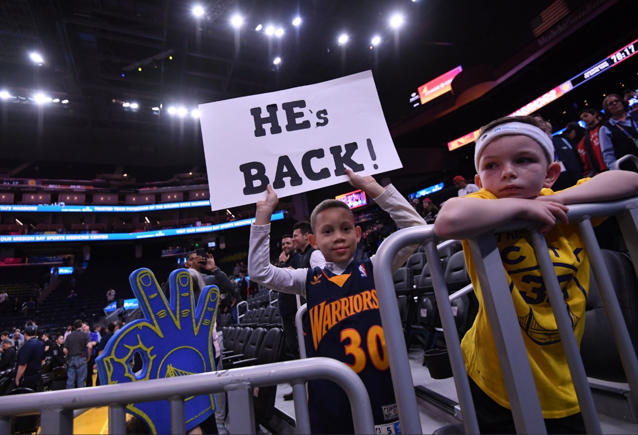 PHOTO Young Kid With A He's Back Sign For Steph Curry