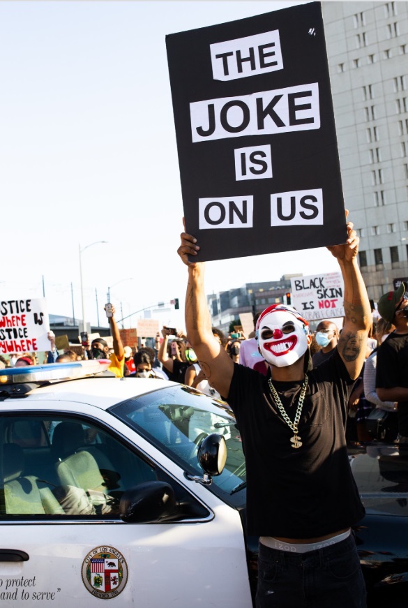 PHOTO LA Protester Holding Sign That Says The Joke Is On Us