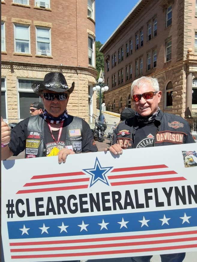 PHOTO Two Motorcyclists Holding Clear General Flynn Sign At Sturgis Motorcycle Rally