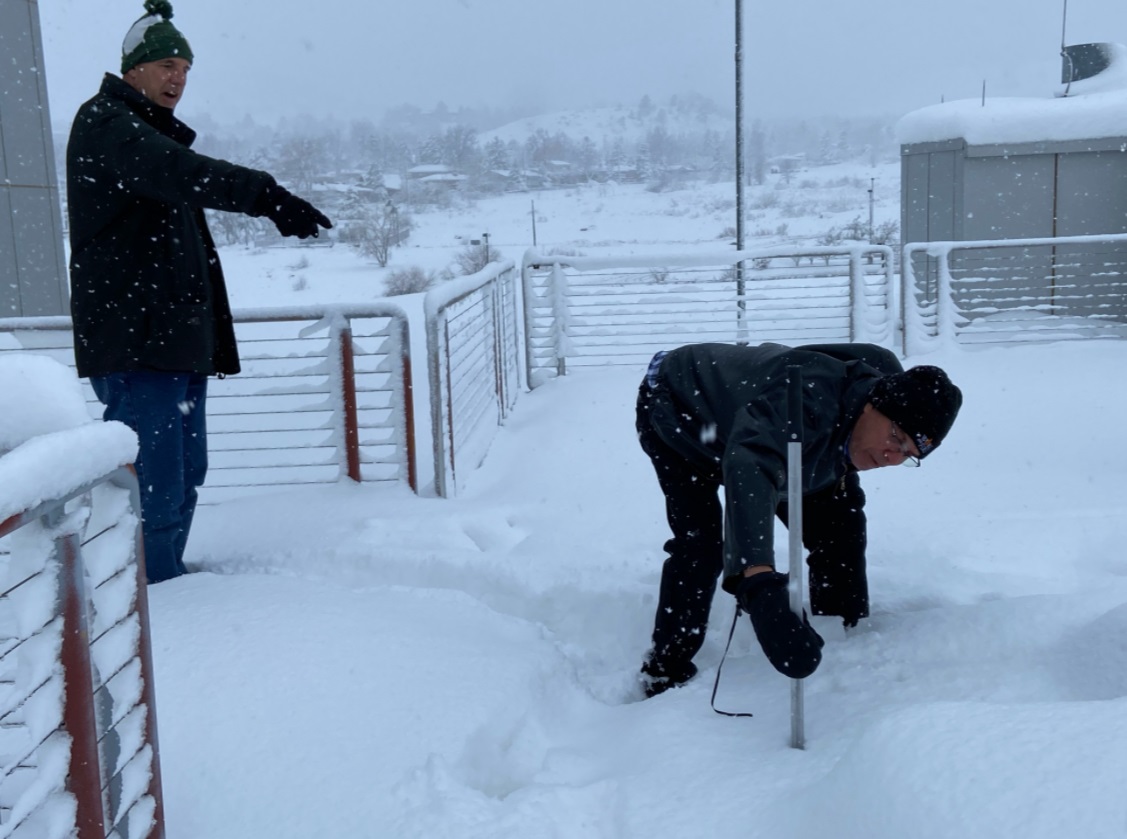 PHOTO Meterologist Measuring 24 Inches Alone On Picnic Table In Denver