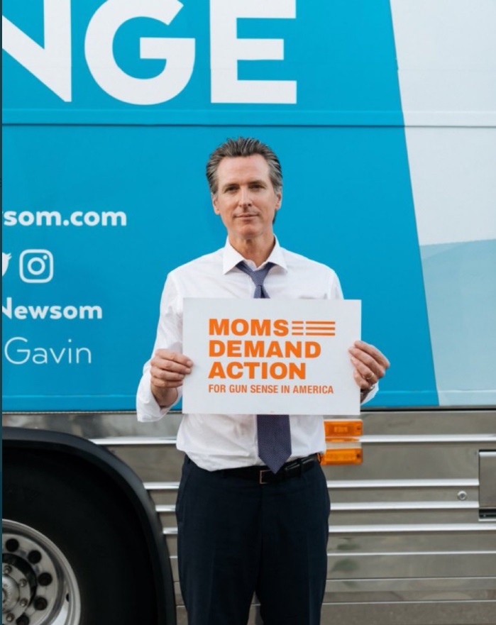 PHOTO Gavin Newsom Looking Like A Shy Little Holding Moms Demand Action Guns Sense Sign