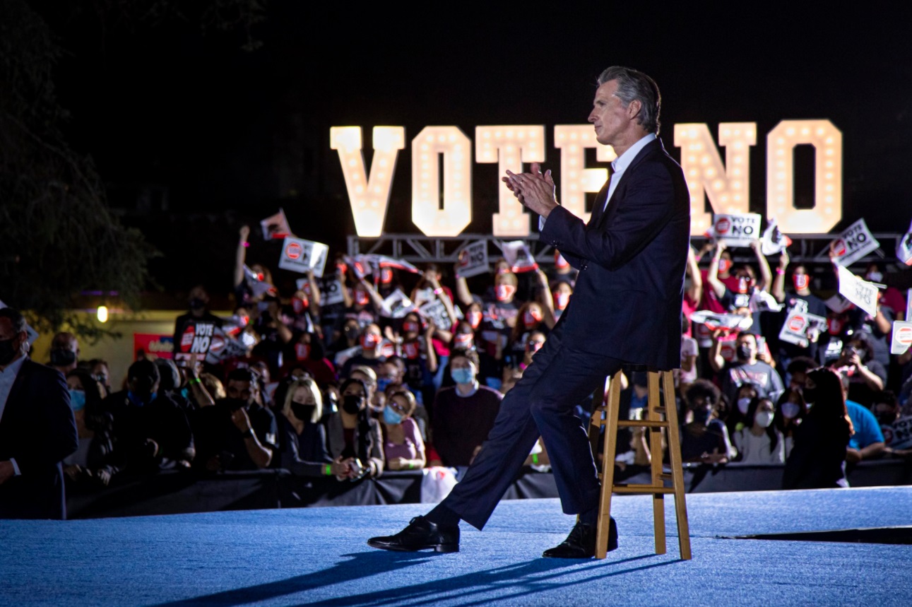 PHOTO Gavin Newsom Sitting Next To A Vote No Sign