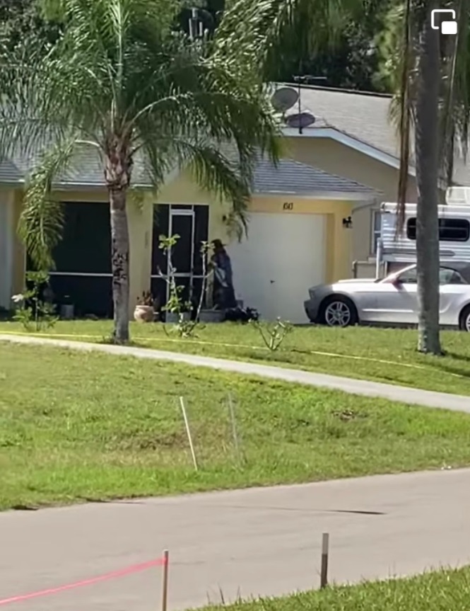 PHOTO Brian Laundrie's Mom Goes Outside To The Trash Can Wearing A Black Sun Dress Looking Like She's Dressed For Halloween