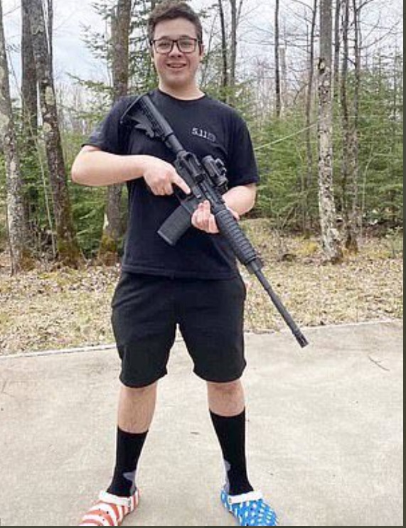 PHOTO Kyle Rittenhouse Wearing American Flag Themed Flip-Flops In The Woods While Holding AR-15