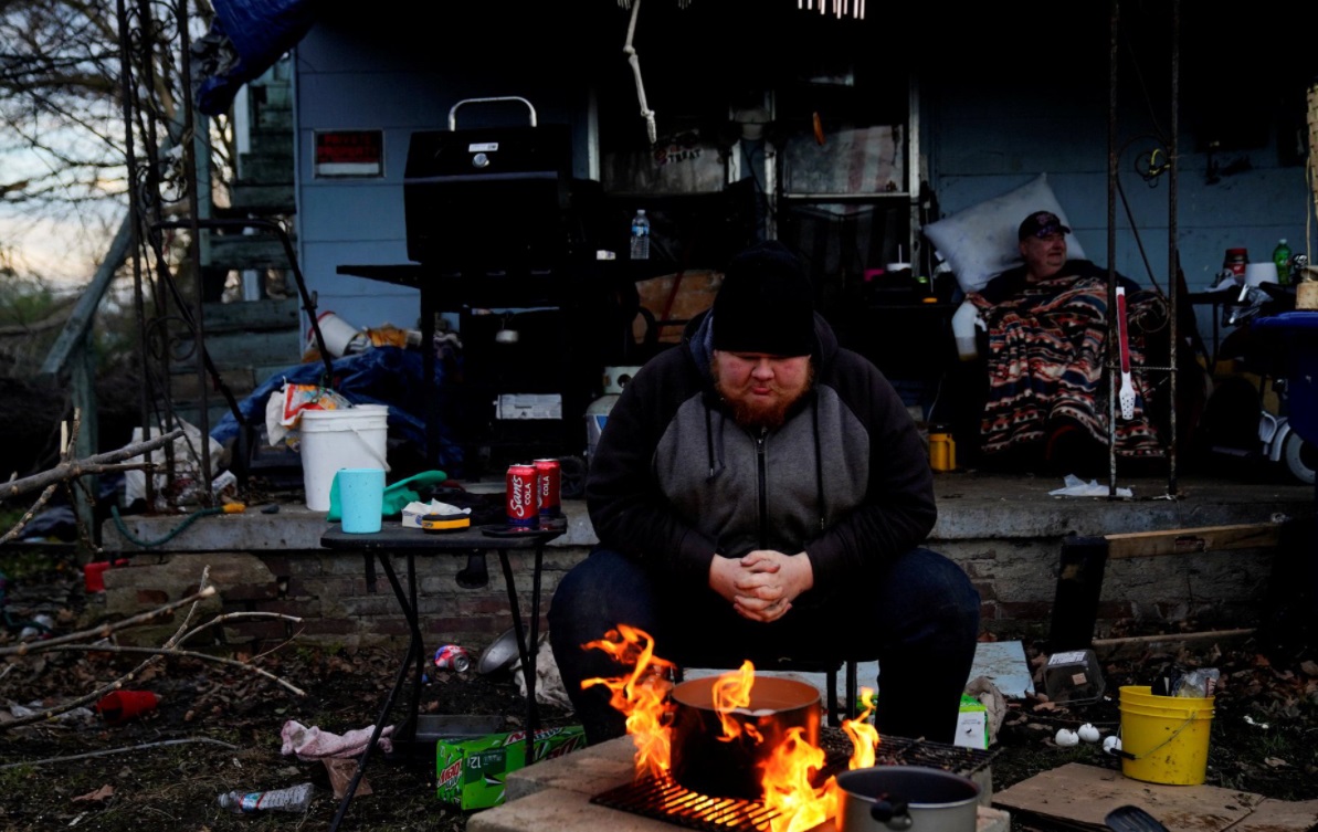 PHOTO 24 Year Old Man Boiling Eggs To Eat And Trying To Stay Warm After His Home Was Damaged In Mayfield Kentucky