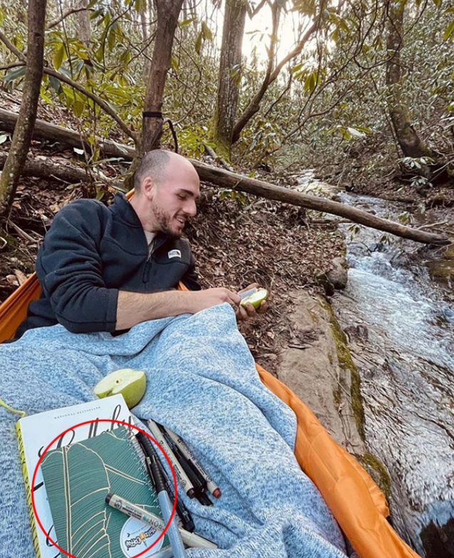 PHOTO Brian Laundrie Writing In His Green Notebook With Sharpie