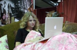 PHOTO Taylor Swift Sitting On Her Bed With A Smirk On Her Computer Starting Trouble