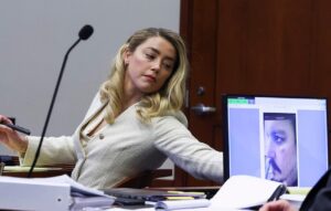 PHOTO Amber Heard Reaching For A Tissue In The Court Room While Taking Notes