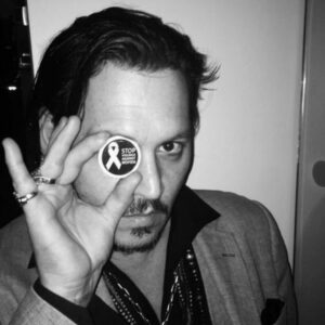 PHOTO Johnny Depp Holding Up A Stop Violence Against Women Pin