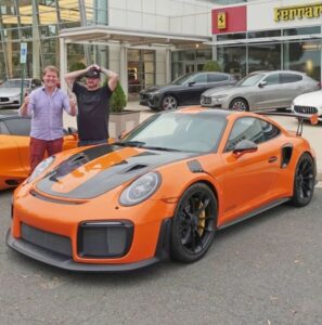 PHOTO Randy Tillim With A Customer Who Bought A Bright Orange Exotic Car