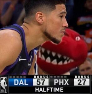 PHOTO Luka Doncic Wearing A Raptor Costume Trying To Taunt Devin Booker Looking Straight Ahead Trying To Ignore Luka