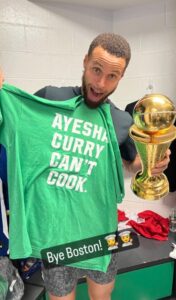 PHOTO Steph Curry Holding A Ayesha Curry Can't Cook Green Celtics T-Shirt In Locker Room After Winning Title