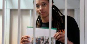 PHOTO Brittney Griner Showing Pictures Of Her Family To The Media Through Her Jail Cell In Russia