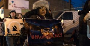 PHOTO Woman Holding Mute R Kelly Sign