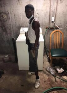 PHOTO Orlando Harris Posing With Long Gun In Basement Of His Parents Home That Looks Like A Slum