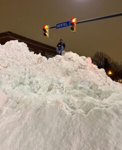 PHOTO Man Sitting On 15 Foot Pile Of Snow On Hertel And Lloyd In Buffalo With Snow Pile Up To Street Traffic Light