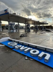 PHOTO Chevron Sign Laying In Parking Lot Of Gas Station That Got Pummeled By Tornado