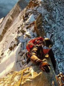 PHOTO Of Julian Sands Climbing A 15 Foot Mountain With A Rope And Heavy Climbing Gear