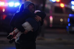 PHOTO Man Carrying Child Out Of El Paso Mall After Mass Shooting