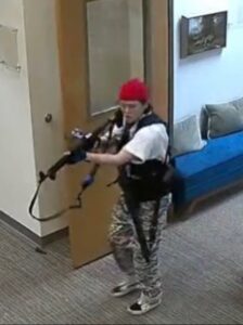 PHOTO Nashville Shooter Audrey Hale Looking Deranged Walking Down Hallway With Red Hat Huge Vest And Camo Pants