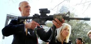 PHOTO Rick Scott Holding A Very Dangerous Automatic Gun With His Finger On The Trigger