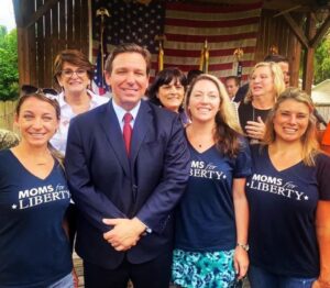 PHOTO Karens With Moms For Liberty T-Shirts Standing Next To Ron DeSantis