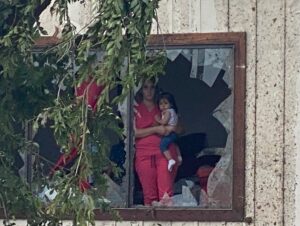 PHOTO Woman Holding Child Inside House After Perryton Tornado Knocked Out Glass Window