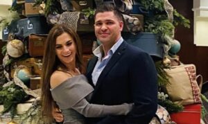 PHOTO Alina Page With Her Hands Around Her Husband's Waist In Front Of Christmas Tree For The Holidays