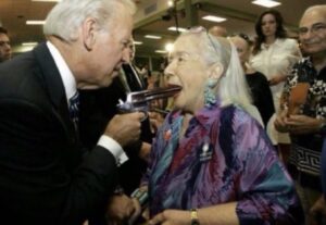 PHOTO Joe Biden Sticking A Gun Inside An Old Ladies Mouth Meme