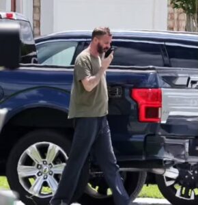 PHOTO John Paul Miller Talking On His Phone With Speakerphone Outside His House