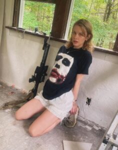 PHOTO Natalie Rupnow Posing With A Big Gun Inside Run Down Cabin Dwelling