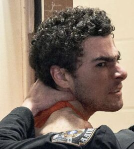 PHOTO Luigi Mangione Getting Squeezed In The Neck While In Custody