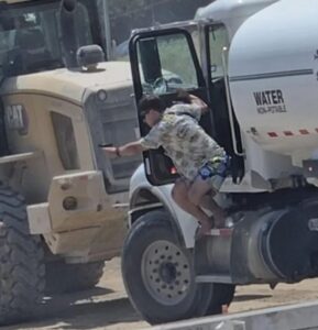 PHOTO Ethan Nieneker Pointing Handgun While Standing Out Of Portable Water Tank Truck