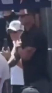 PHOTO Close Up Of Dude In Black Shirt Giving Hand Signals Behind Charlie Kirk Before He Was Shot