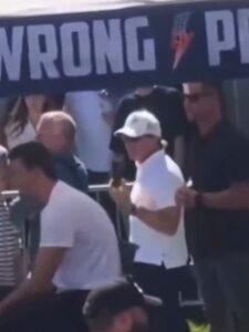 PHOTO HD Picture Of Man In Black Shirt Giving Out Hand Signals Behind Charlie Kirk At UVU Event