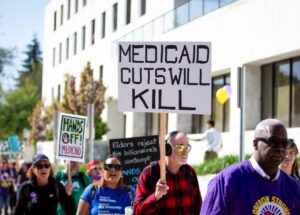 PHOTO Medicaid Cuts Will Kill Protesters Holding Up Sign Day Before The Government Shuts Down