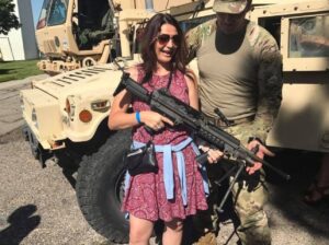 PHOTO Tyler Robinson’s Mom Holding Military Weapon In Front Of Armored Vehicle