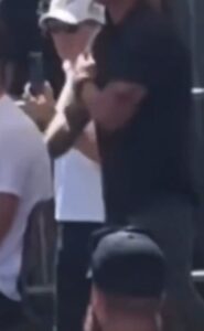 PHOTO Zoomed In Still Shot Of Man Giving Off Noticeable Hand Signals During Charlie Kirk Speaking Event