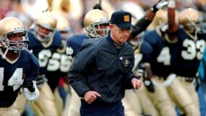 PHOTO Lou Holtz Leading Notre Dame On The Field